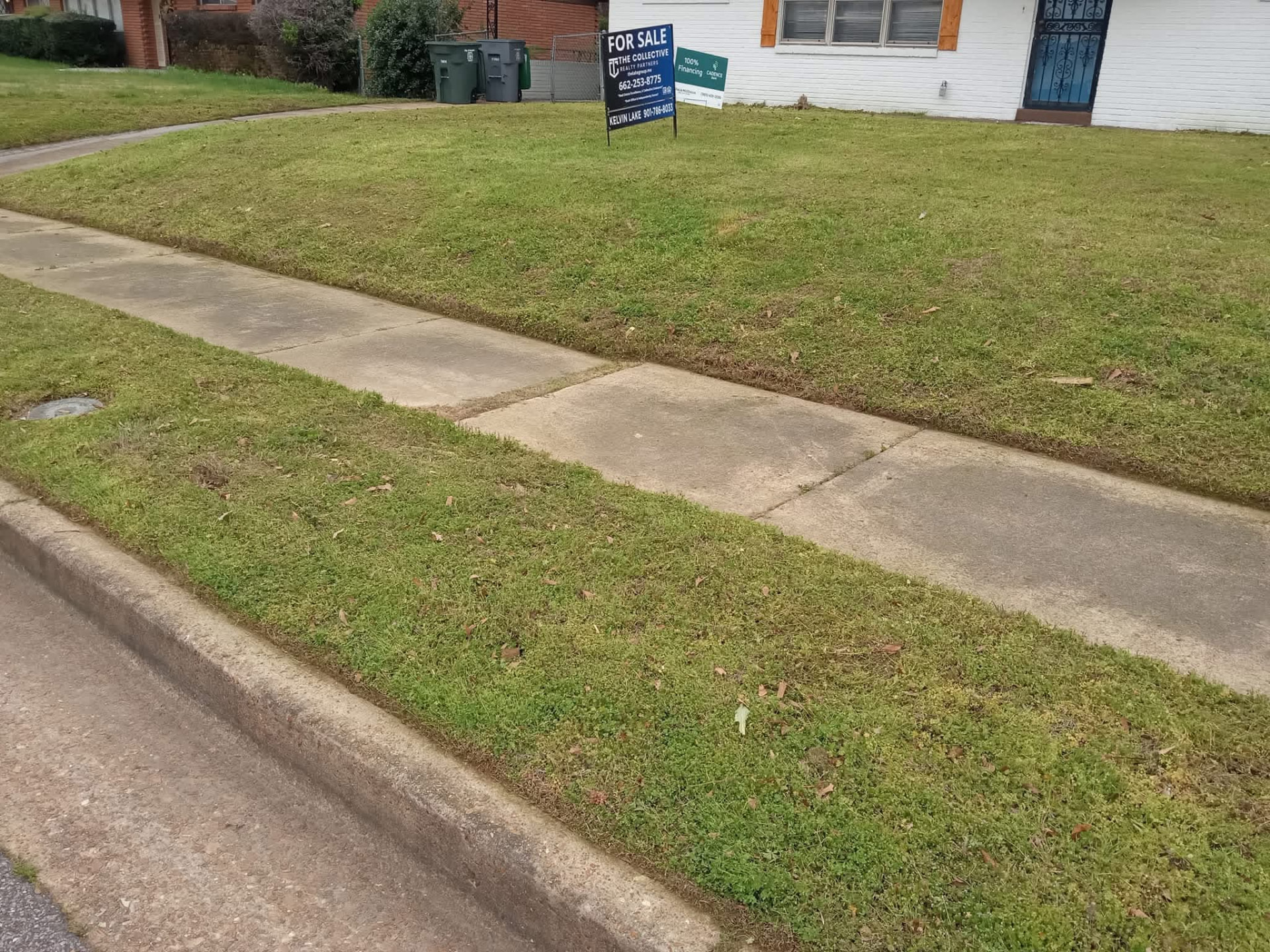 The same Memphis front lawn mowed with a clean sidewalk edge after service